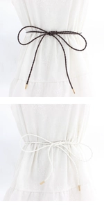 Detail of woven PU waist ropes in brown and white with golden metal ends for dresses