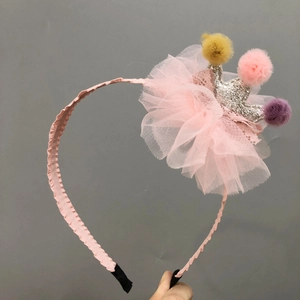 Detail of pink tulle headband featuring silver sequin crown and colorful fuzzy balls