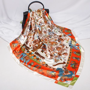 Close-up of ethnic tree of life pattern silk scarf draped elegantly on a black handbag