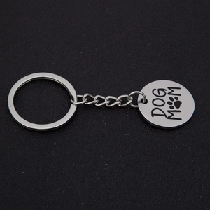 Polished stainless steel Dog Mom keychain with paw print pendant on black background