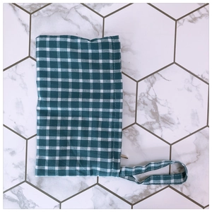 Detail of green gingham fabric pouch with neat stitching and convenient wristlet strap