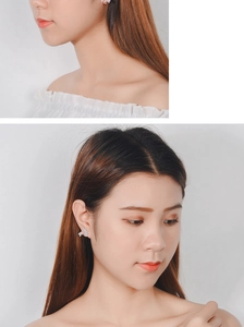 Detailed view of silver leaf-shaped earrings with sparkling cubic zirconia on a model