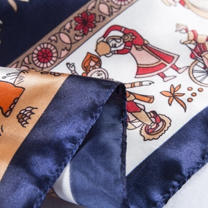 Detailed close-up of ethnic silk scarf showing intricate blue and orange floral patterns
