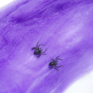 Halloween decor featuring two black plastic spiders on purple cotton spider web material