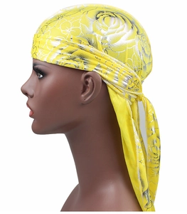 Detailed view of yellow silky durag featuring metallic silver rose floral patterns