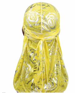 Macro shot of yellow silky durag featuring silver rose print and back knot detail