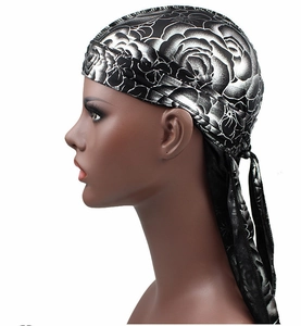 Detailed side view of silky durag with white rose print on black satin fabric