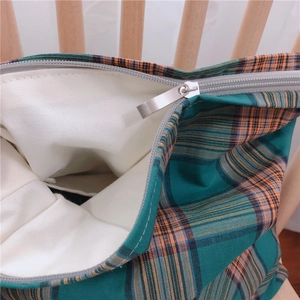 Vue détaillée du sac en toile à carreaux avec poche intérieure et zip métallique