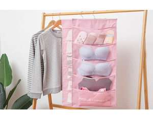 Detail of pink double-sided hanging storage bag with mesh pockets and metal hook for closet