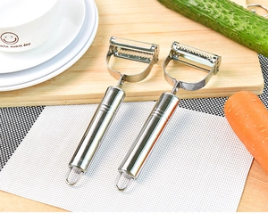 Dual-head stainless steel vegetable peeler and grater set on a kitchen cutting board
