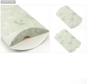 Detail view of pillow-shaped paper gift box with green floral pattern and leaf prints