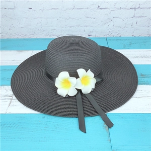 Women's black wide brim straw sun hat with white frangipani flowers and silk ribbon