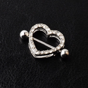 Silver heart-shaped nipple shield with sparkling crystals on black leather background