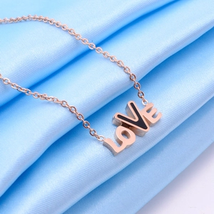 Minimalist rose gold LOVE pendant necklace on blue silk background for women