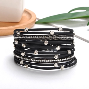 Macro detail of multi-layer black leather bracelet featuring silver magnetic clasp and rhinestones