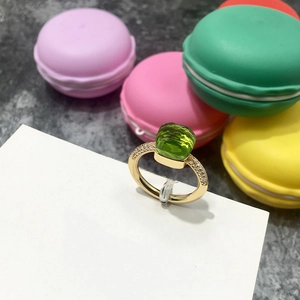 Detalle de anillo de cristal verde esmeralda con pavé de diamantes en banda dorada