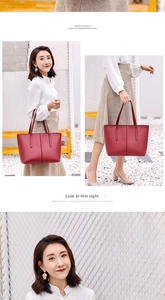 Detail view of the deep red leather tote bag with vertical stitching and slim straps