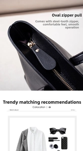 Detail of golden oval metal zipper pull and steel teeth on black leather tote bag