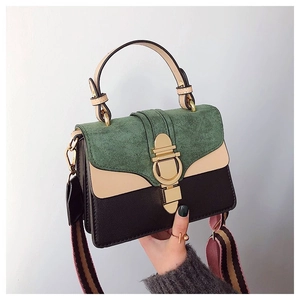 Detail of color-block crossbody bag with suede flap and gold twist-lock closure