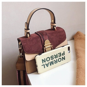 Detail of color-block crossbody bag with burgundy suede flap and gold metal buckle lock
