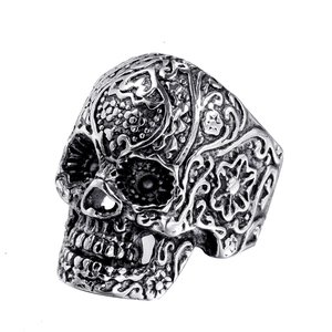 Vintage skull ring for men in stainless steel with detailed floral carvings on white background