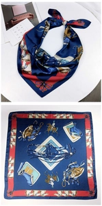 Detailed view of silk scarf with equestrian horse prints and red border on navy satin