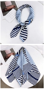 Close-up of geometric striped silk scarf in blue and white with elegant knotted detail