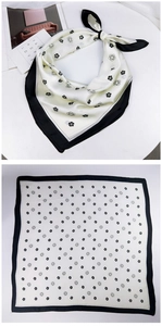 Detailed view of silk square scarf featuring camellia prints and black contrast borders