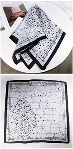 Macro detail of square silk scarf with vintage celestial star map and Roman numerals
