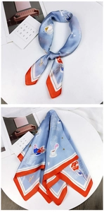 Detail of light blue and orange silk scarf with floral patterns and French typography