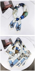 Detail view of silk scarf with equestrian horse print in blue and white patterns