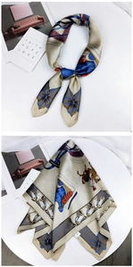 Close-up of champagne silk square scarf featuring equestrian horse and bit pattern details