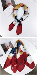 Detail of silk-like neck scarf showing vibrant color block patterns and smooth satin texture