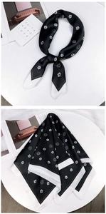 Detail of a black and white silk scarf with camellia pattern and elegant knotted styling