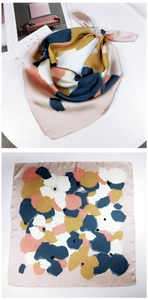 Detail of square silk scarf with abstract floral pattern in navy blue and ginger yellow
