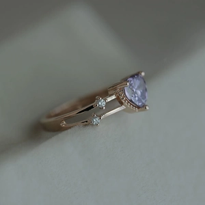 Macro side view of heart-shaped purple zircon ring with 14k rose gold plated band