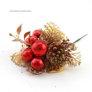 Christmas decoration featuring red berries, golden leaves, and pinecone with gold glitter