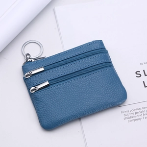 Close-up of blue litchi grain leather coin purse with triple zippers and silver keyring
