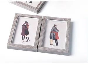 Close-up of double folding gray wood grain picture frames with clear glass panels