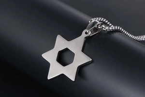 Macro view of vintage hollow hexagram pendant on polished stainless steel chain