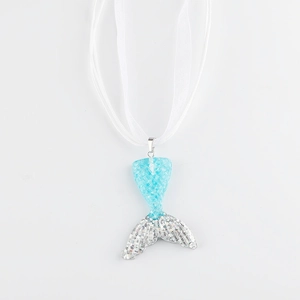 Macro shot of gradient blue mermaid tail pendant with shiny sequins and white ribbon cord