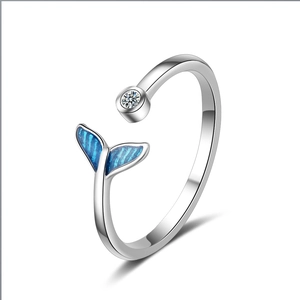 Silver open ring with blue whale tail design and crystal stone on white background