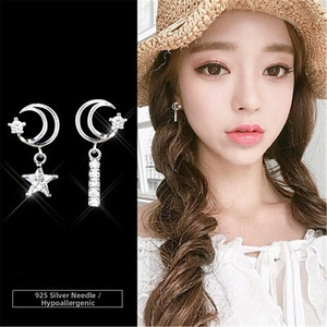 Detailed view of asymmetric moon and star earrings with sparkling cubic zirconia stones