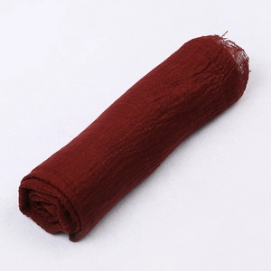 Detail shot of a dark red crinkle cotton scarf showing its soft breathable texture