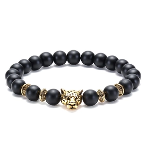 Detailed macro view of 8mm matte black beads and a golden leopard head charm on the bracelet
