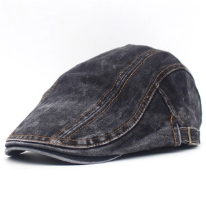 Detail view of washed dark gray denim beret featuring yellow contrast stitching accents