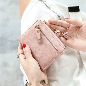 Detailed close-up of a pink PU leather short wallet with a stylish gold chain and metal balls