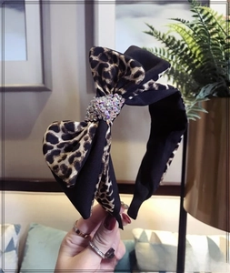 Detail of leopard print double bow headband with shiny rhinestones and fabric wrapping