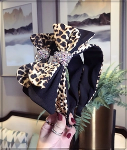 Detail of leopard print bow headband featuring sparkling colorful rhinestones on fabric