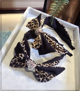 Detail of leopard print double-layered bow headbands with colorful rhinestone centers